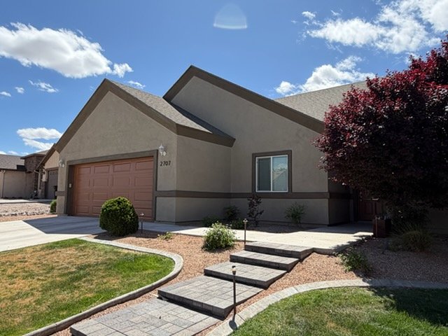 Tan stucco home with garage