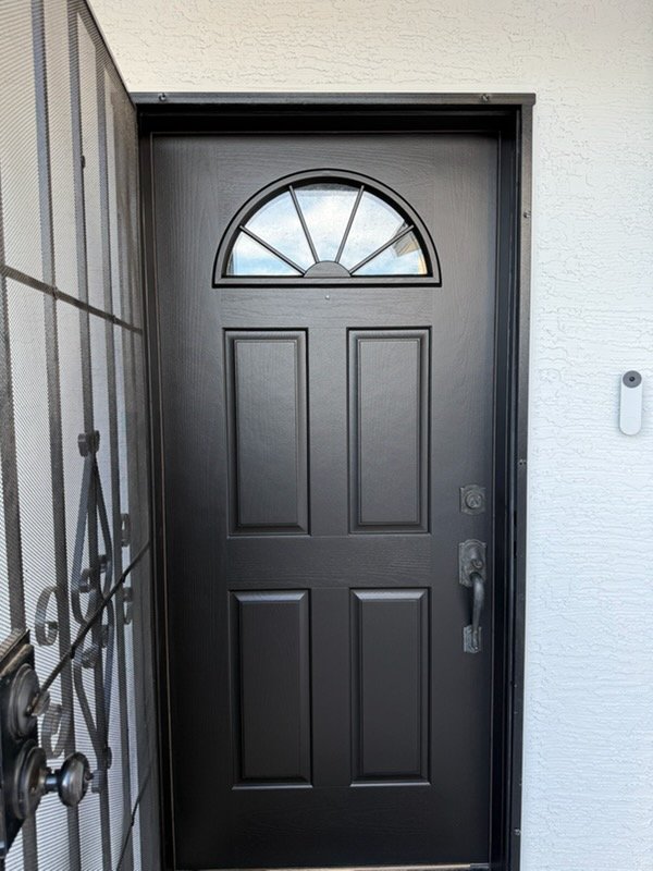 Black painted front door on stucco