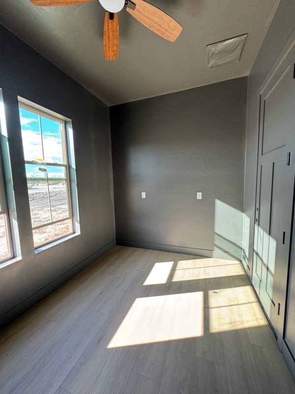 Dark grey painted bedroom with ceiling fan