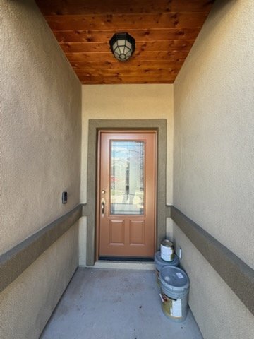 Front entry door with wood-stained ceiling