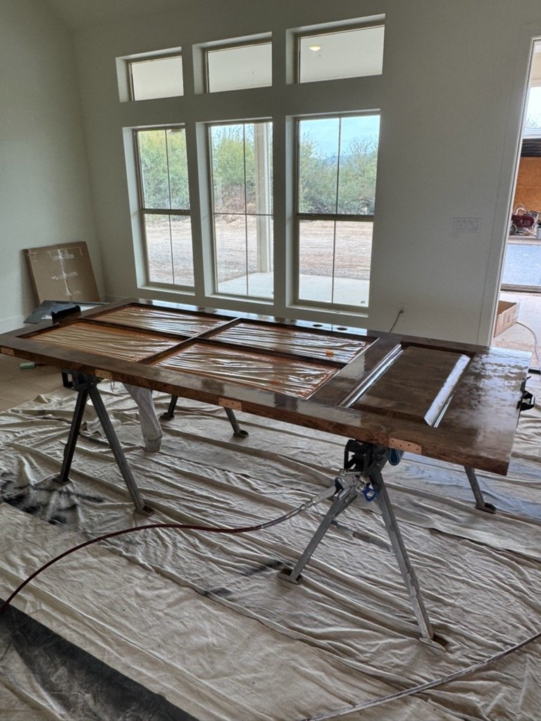Wood door being stained on sawhorses