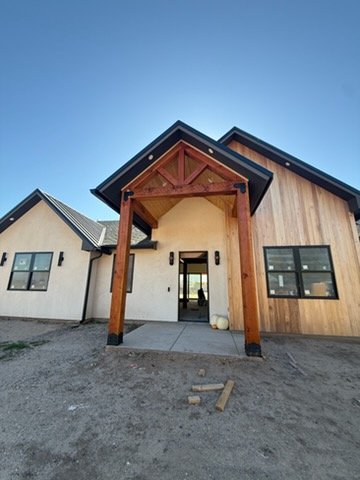 Stained wood beam entry with stucco